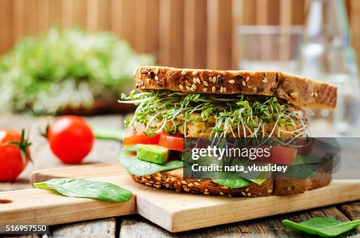 Sprouts avocado tomato spinach chickpeas burger rye sandwich Sprouts avocado tomato spinach chickpeas burger rye sandwich