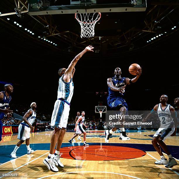 Michael Jordan of the Washington Wizards drives to the basket for a layup against the Charlotte Hornets on December 26, 2001 during an NBA game at...