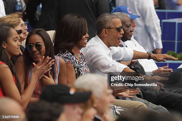Malia Obama, Sasha Obama, U.S. First lady Michelle Obama, President Barack Obama and Cuban President Raul Castro react to the first run scored during...