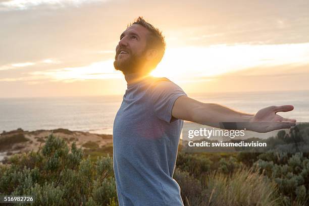 hombre joven disfrutando de la vida - brazos estirados fotografías e imágenes de stock