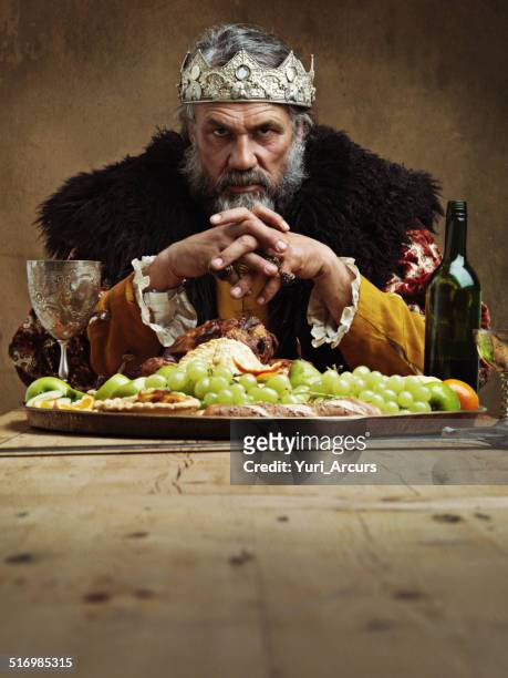 he feasts while the serfs starve - king royal person stock pictures, royalty-free photos & images