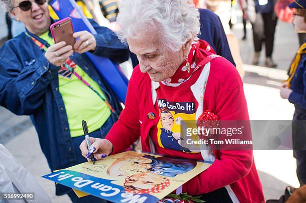 Sylvia Tanis, a Rosie the Riveter during World War II, signs a poster at the WWII Memorial, March 22, 2016. Tanis was part of an Honor Flight from...