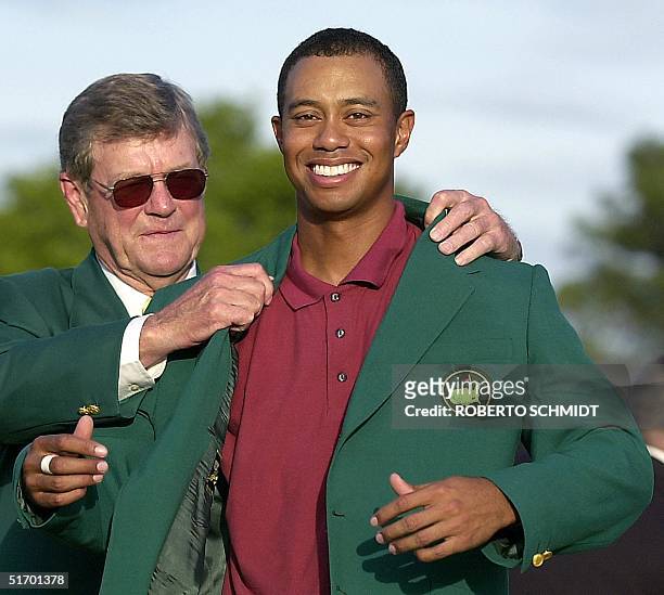 Tiger Woods receives the green jacket from tournament chairman Hootie Johnson 14 April 2002, after winning his second straight Masters Tournament at...