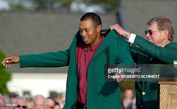 Tiger Woods of the US gets his third green jacket from tournament chairman Hootie Johnson 14 April 2002, after winning the 2002 Masters golf...