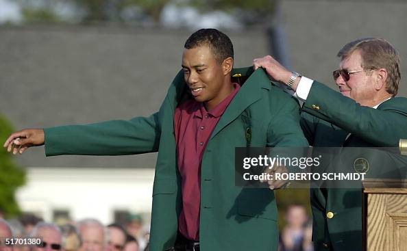 Tiger Woods (L) of the US gets his third green jac