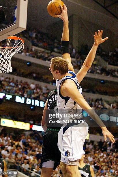 Dirk Nowitzki of the Dallas Mavericks leaps and dunks over Rasho Nesterovic of the Minnesota Timberwolves during first half action of their Western...