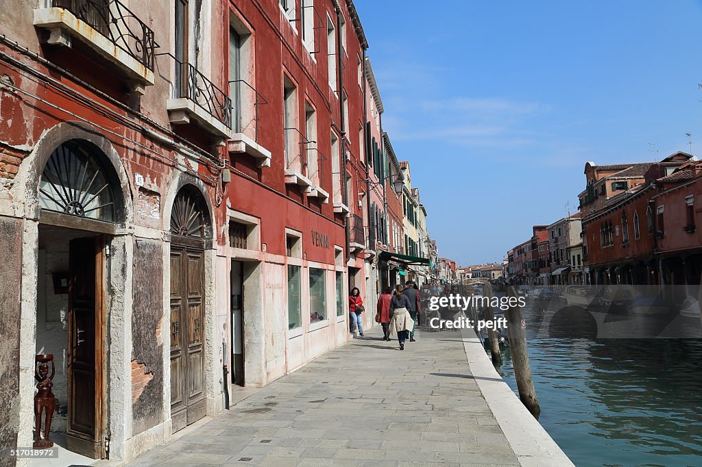 Canal, pessoas e lojas de Murano