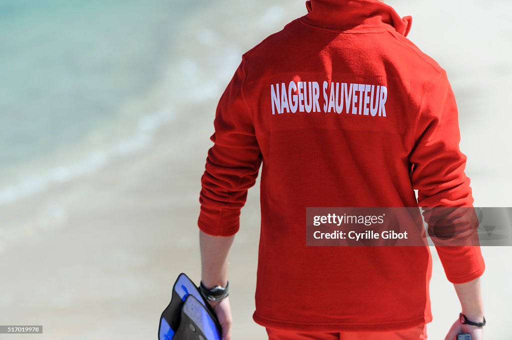 Lifeguard walks down the beach