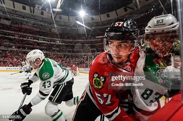 Trevor van Riemsdyk of the Chicago Blackhawks pushes Ales Hemsky of the Dallas Stars into the glass as Valeri Nichushkin skates in the background in...