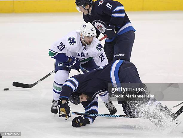 Chris Thorburn of the Winnipeg Jets gets tied up with Chris Higgins of the Vancouver Canucks in third period action in an NHL game at the MTS Centre...