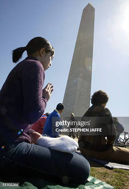 Falun Gong practitioners meditate in the shadow of the Washington Monument 28 March, 2002 in Washington, DC. The practitioners are on a six-day round...