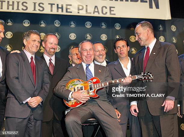 New York City Mayor Michael Bloomberg holds a Les Paul guitar donated by Les Paul at a press conference in New York 03 April 2002 to announce that...