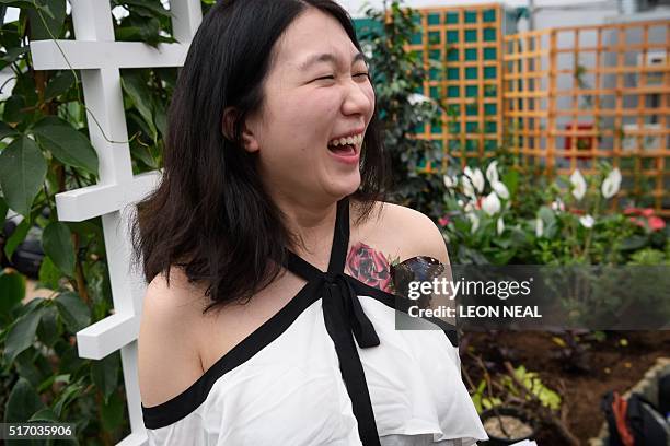 Journalist poses for pictures with a Morpho Peleides butterfly on her rose tattoo during a photocall at the Natural History Museum in central London...