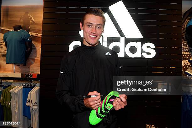 Darcy Moore of Collingwood Football Club signs his autograph at the new adidas Bourke Street Store on March 23, 2016 in Melbourne, Australia.
