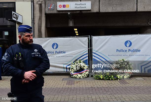 Policeman stands next to flower wreaths laid by French Prime Minister Manuel Valls, Belgium Prime Minister Charles Michel and European Commission...