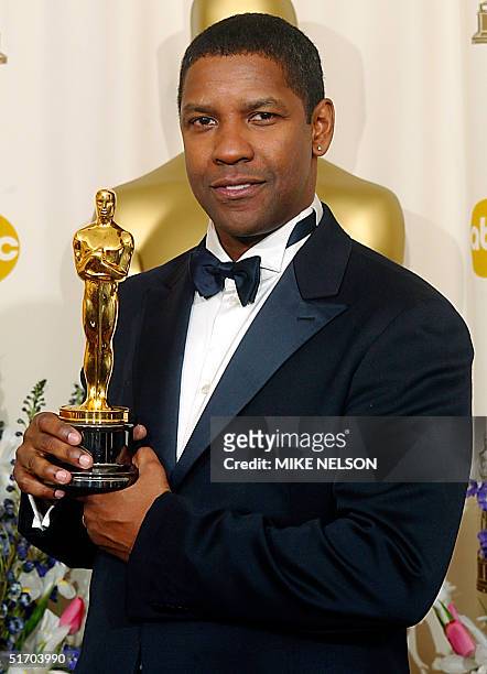 Actor Denzel Washington holds his Oscar after winning the award for best actor in a leading role for his portrayal of Alonzo, a narcotics officer who...