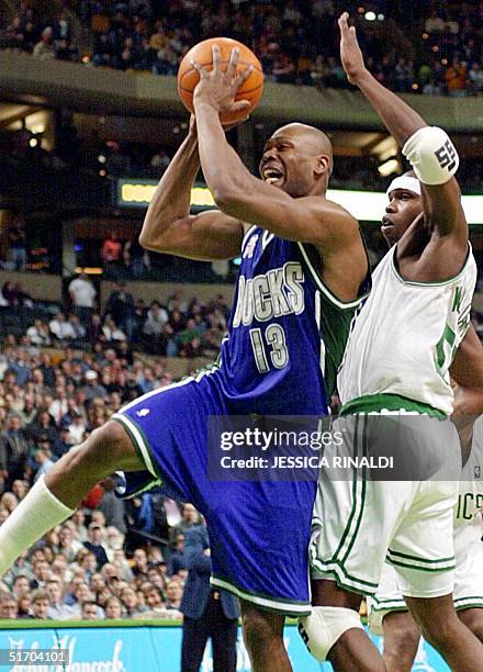 Eric Williams of the Boston Celtics tries to stop Glenn Robinson of the Milwaukee Bucks on his way to the basket during the fourth quarter, 27...