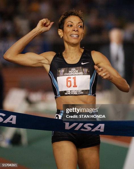 Regina Jacobs raises her fist as she wins the women's mile during the