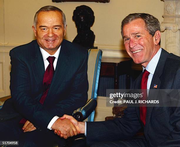 President George W. Bush welcomes Uzebekistan President Islom Karimov to the Oval Office 12 March 2002 with a hand shake during a private meeting at...
