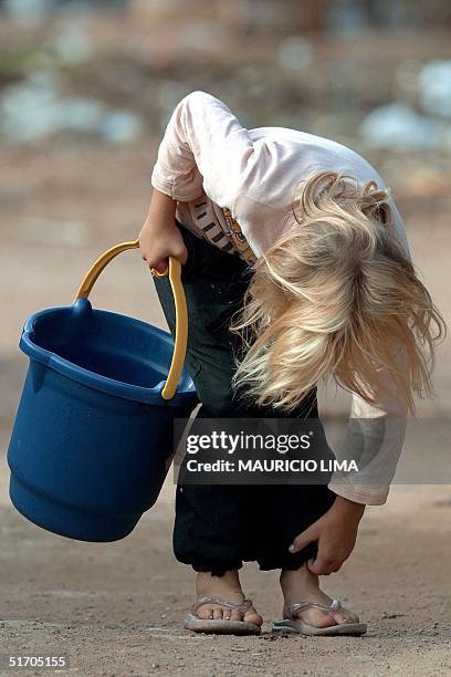 Child adjusts her pants as she searches for water in Porto Alegre, Brazil 02 February 2002. Una nina se entretiene mientras se dirige a buscar agua,...