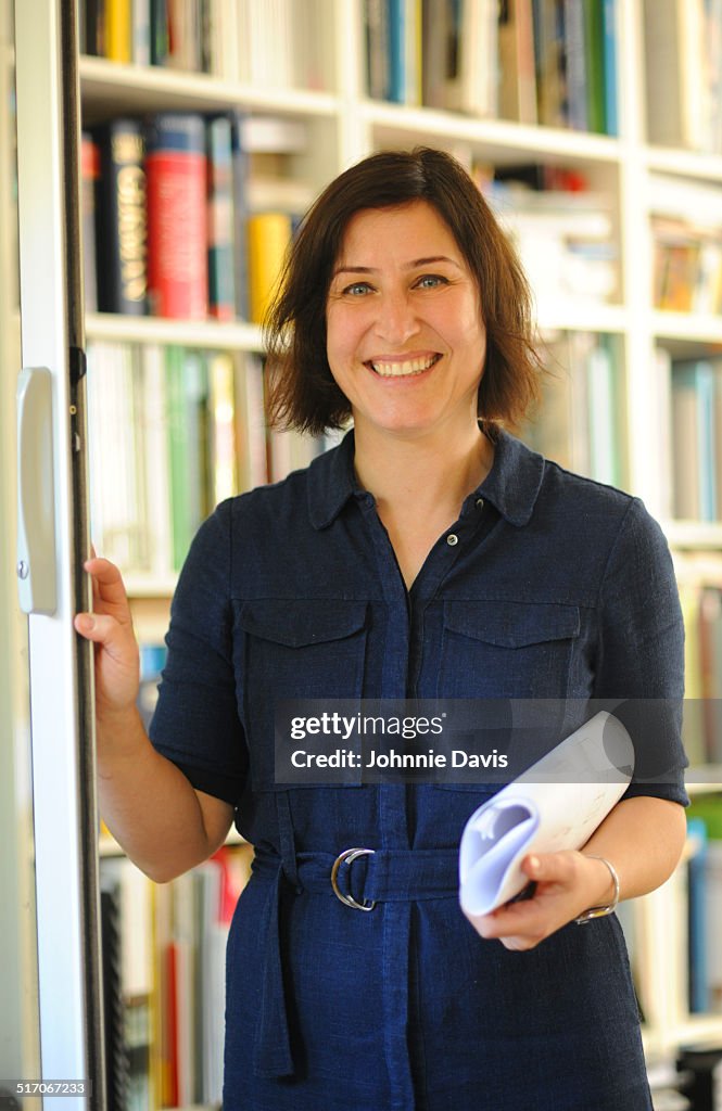 Portrait of professional mature woman by bookcase