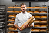 Baker holding baguettes at the manufacturing