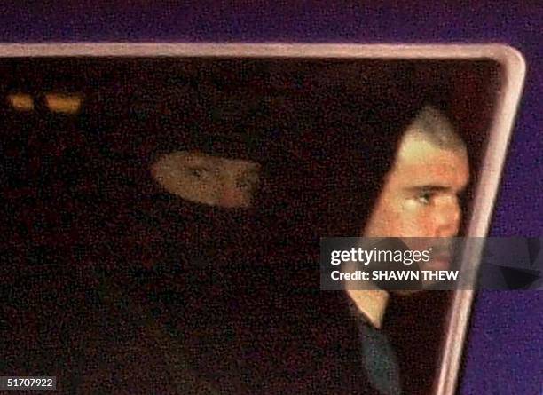 Taliban fighter John Walker Lindh rides in the back seat with a security officer 23 January 2002 as they arrive at the Alexandria Detention Center in...