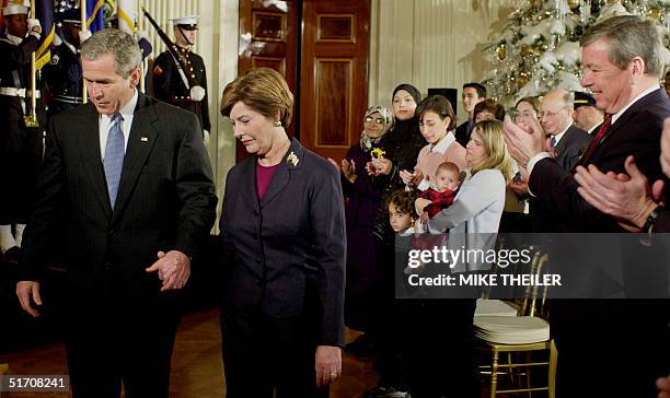 President George W. Bush and first lady Laura arrive for a "The World Will Always Remember" ceremony in the East Room of the White House 11 December,...