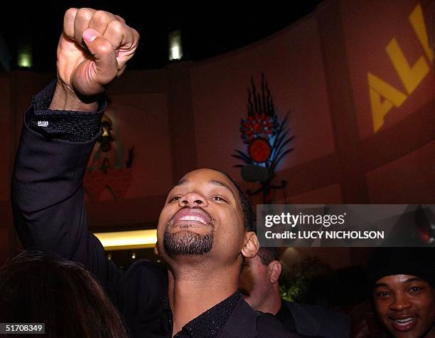 Actor Will Smith lifts his head above the crowd and clenches his fist as he enters the cinema to see the premiere of his new film "Ali," in which he...