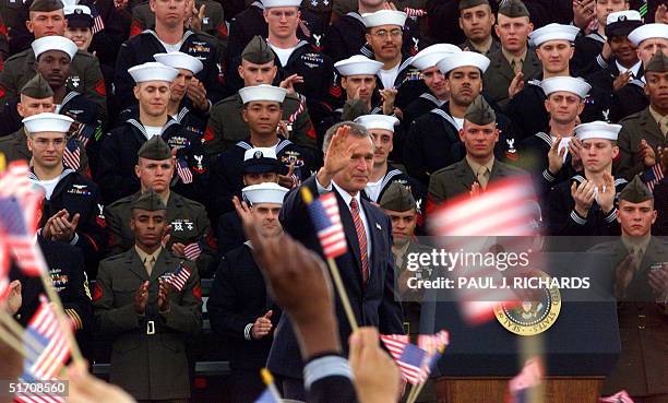 President George W. Bush waves after giving an address to crewmen-returned from duty in Operation Enduring Freedom-on the flight deck of the USS...