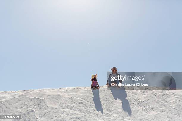 father and daughter sitting on a hill - white sand dune stock pictures, royalty-free photos & images