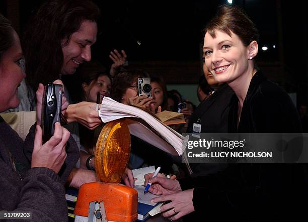 British actress Catherine McCormack signs autographs as she arrives at the premiere of the film "Spy Game," in which she stars with Brad Pitt and...