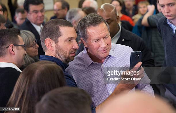 Republican presidential candidate Ohio Gov. John Kasich greets guests following a campaign rally at the Crowne Plaza Milwaukee West hotel on March...