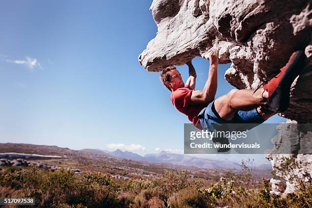 felsklettern beim bouldern im freien auf die berge in natur - freeclimber stock-fotos und bilder