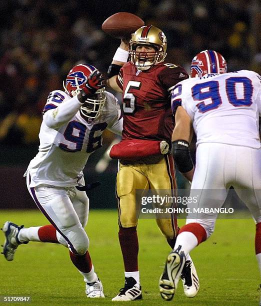 San Francisco 49ers' quarterback Jeff Garcia hurries a pass as Buffalo Bills' defensive tackle Erik Flowers and defensive tackle Phil Hansen pressure...