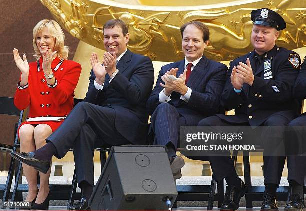 Britain's Prince Andrew applauds as he watches performers 15 October at the opening of the ice skating rink at Rockefeller Center in New York. With...