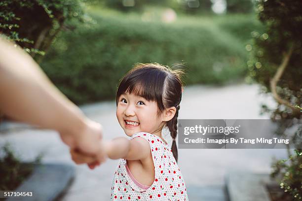 lovely toddler leading her dad by hand - child and unusual angle stockfoto's en -beelden