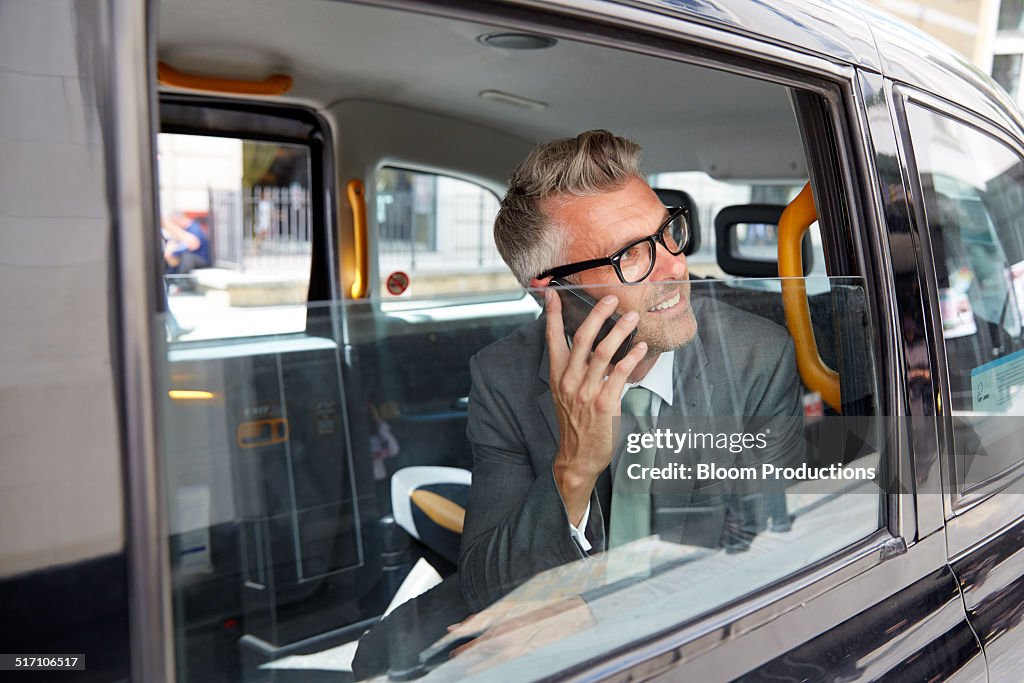 Business man using a smart phone in a taxi