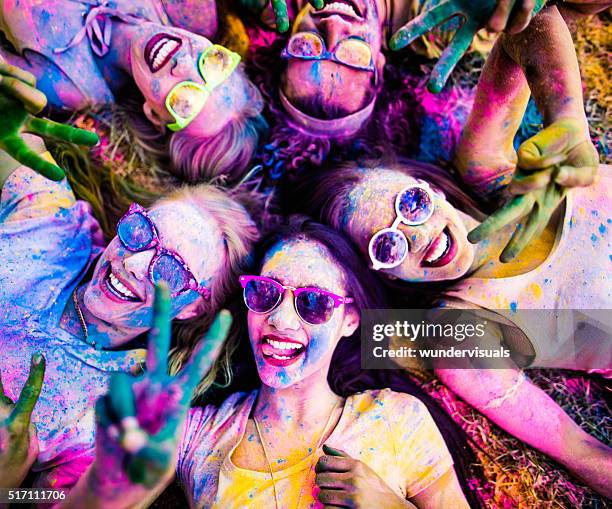 grupo multiétnico celebrando festival de holi no parque - colour festival imagens e fotografias de stock