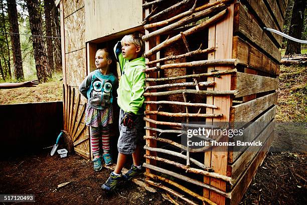 smiling girl and boy standing in fort at camp - girls with short skirts photos et images de collection