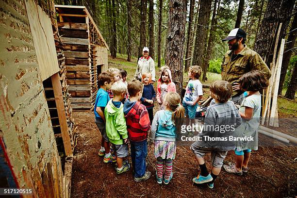 camp counselor giving instructions to kids - ferienlager stock-fotos und bilder