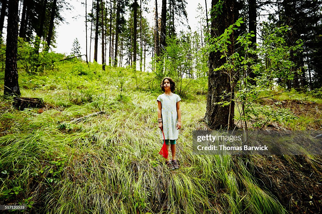 Young girl at summer camp standing in forest