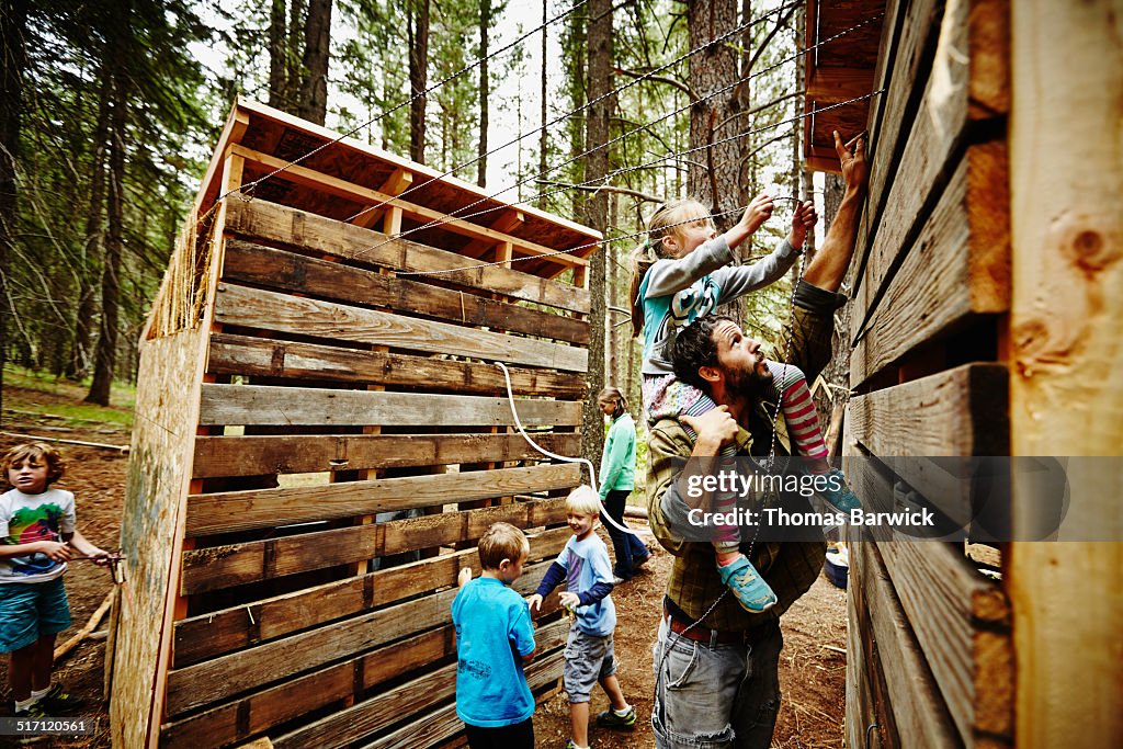 Young girl riding on camp counselors shoulders