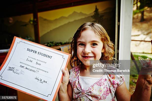 Girl holding up award after finishing summer camp