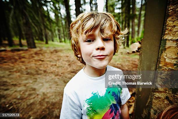 young boy standing in the woods at camp - sólo niños varones fotografías e imágenes de stock