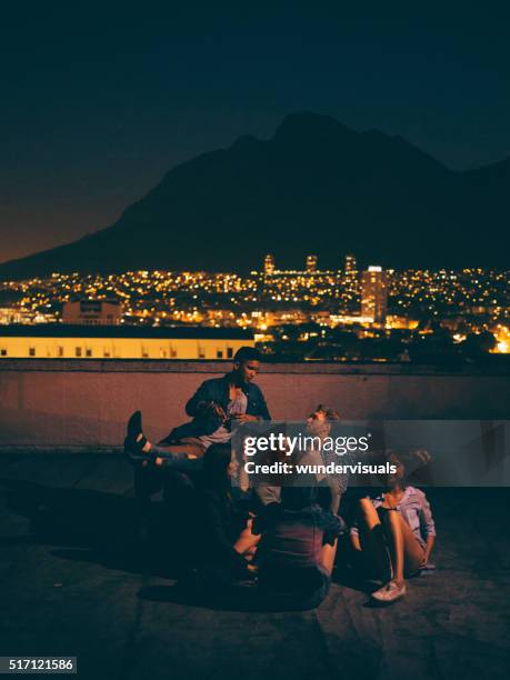 young friends hanging out on the rooftop for a party - rooftop at night bildbanksfoton och bilder