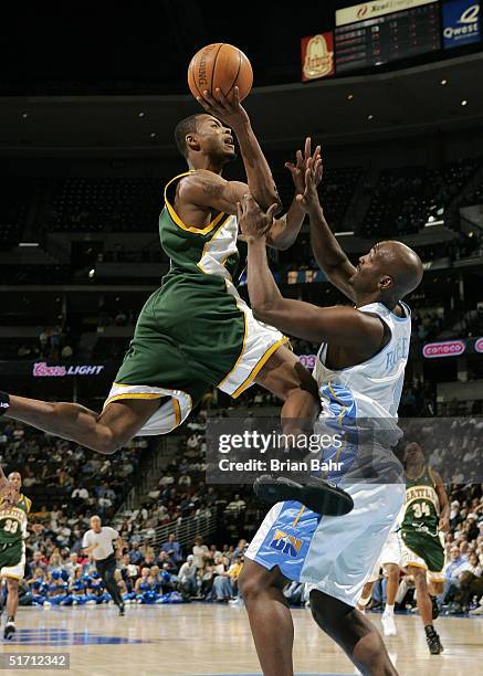 Rashard Lewis of the Seattle SuperSonics plows over Bryon Russell of the Denver Nuggets in the fourth quarter at the Pepsi Center on November 9, 2004...