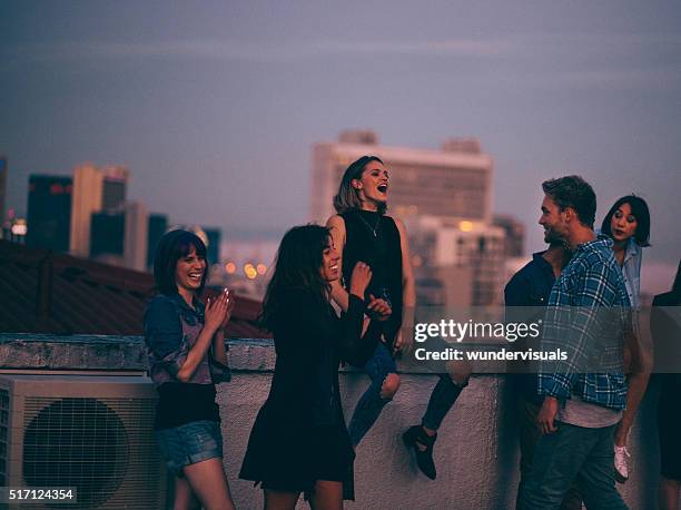 teens celebrating a funny rooftop party - party friends stockfoto's en -beelden