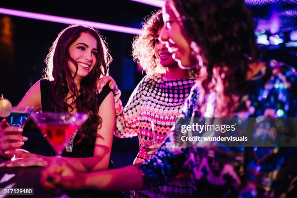 young women chatting with drinks in a night club - girl swing stockfoto's en -beelden