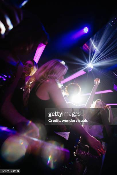 alegre niñas bailando juntos en un club nocturno - luces de discoteca fotografías e imágenes de stock